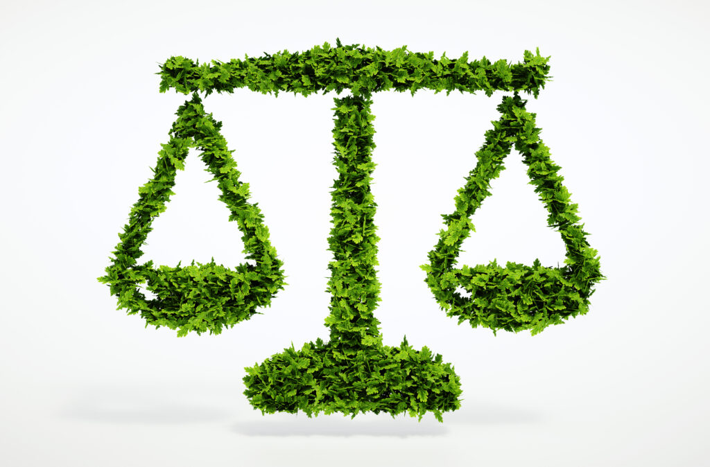 Scales of justice formed from green foliage representing arborist expert witness and litigation support services.